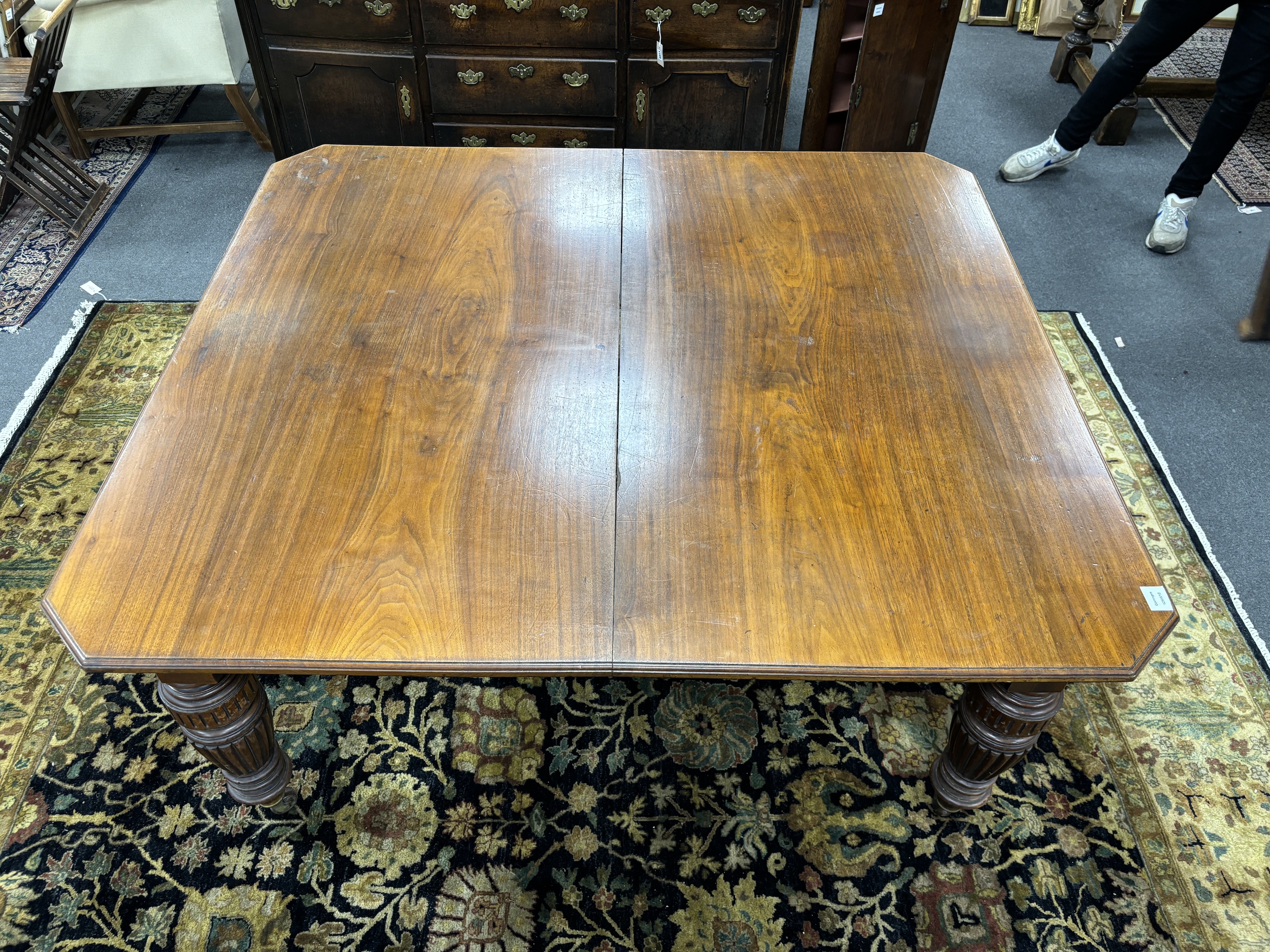 A late Victorian walnut extending dining table, on turned fluted baluster legs, 240cm extended, two spare leaves, depth 137cm, height 73cm